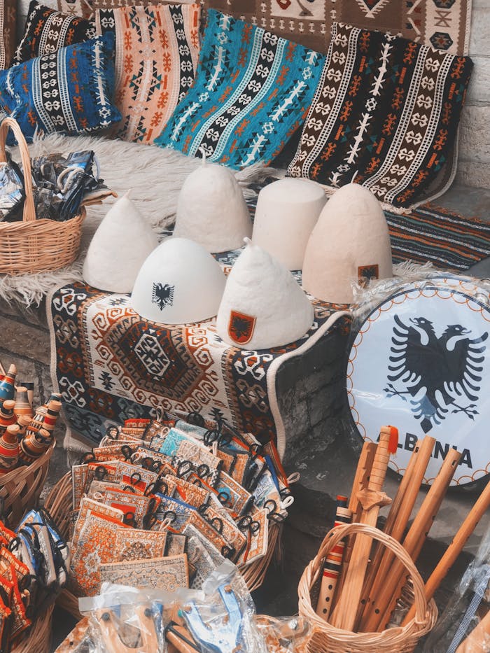 Colorful display of traditional Albanian souvenirs in a market, featuring handcrafted items and decorative textiles.